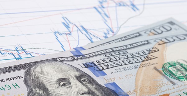 Graph of dividend yields with 100 dollar bills stacked on top