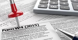 Red stick pin in a stack of tax forms