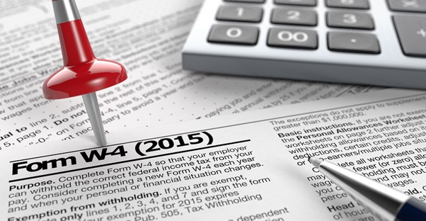Red stick pin in a stack of tax forms