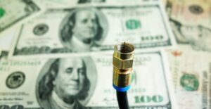 An image of a stack of money behind an unused cable cord