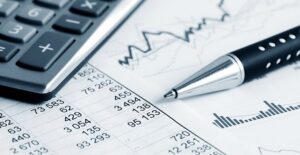 Pen laying next to a calculator on a printout of fund performance