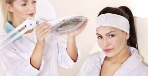 A medical esthetician performs a laser treatment on a patient