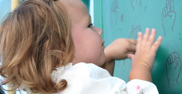 A toddler learns sign language