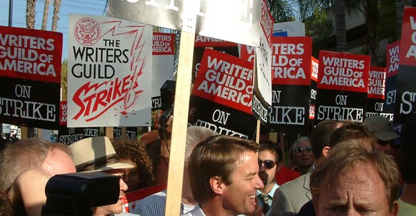Postal worker on strike holding a sign