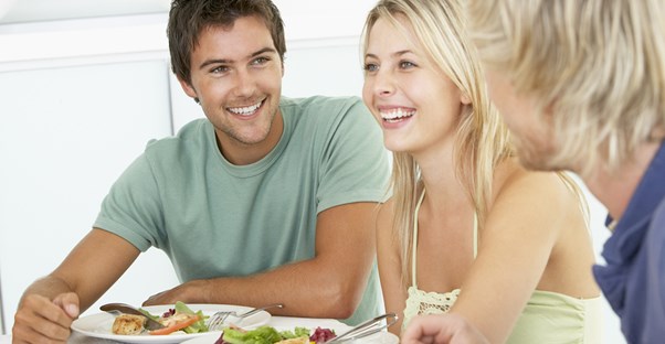 Young people smiling because they're saving money while eating out.