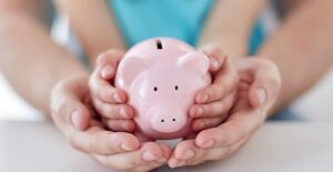 A piggy bank being held to symbolize creating a budget.