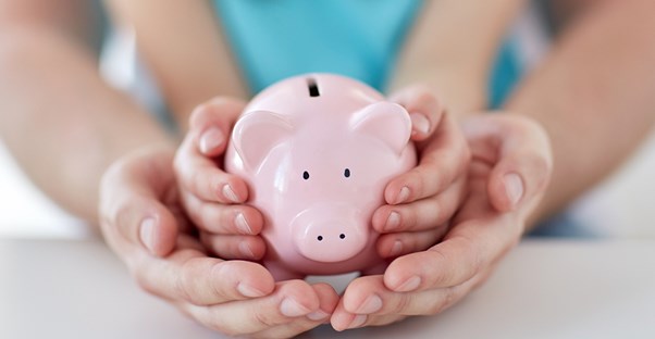 A piggy bank being held to symbolize creating a budget.