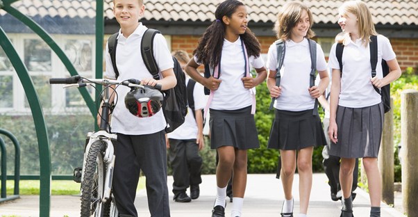 Young students walk home after school in their matching school uniforms