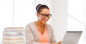 Woman sitting at a desk with a stack of books