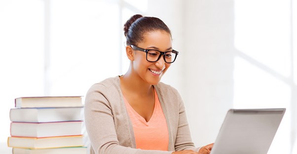 Woman sitting at a desk with a stack of books
