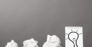 Crumpled pieces of paper next to the finished lightbulb idea