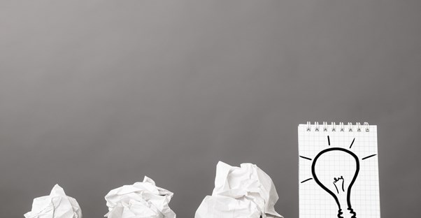 Crumpled pieces of paper next to the finished lightbulb idea