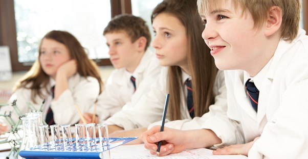 Students take notes while their teacher talks