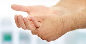 a man grasps his hands in pain