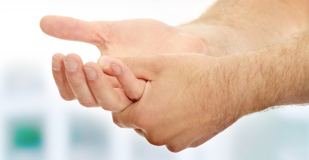 a man grasps his hands in pain