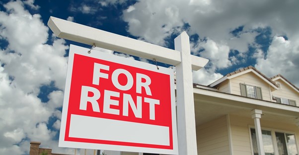 A house and a blue sky with a for rent sign