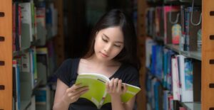 A young girl reads a book in the school library
