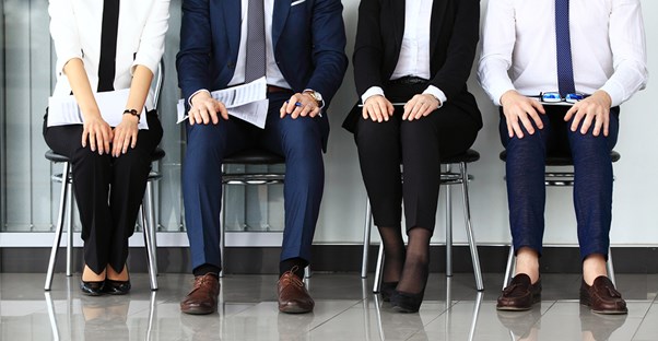 Young professionals sit and wait in a waiting room
