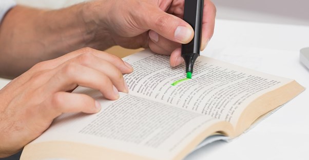 A student highlights a sentence in a textbook