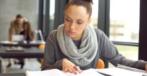 A young college student studies for an exam