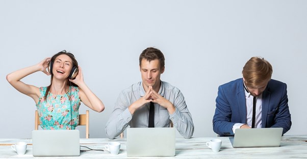 A woman listens to really loud music and annoys her coworkers