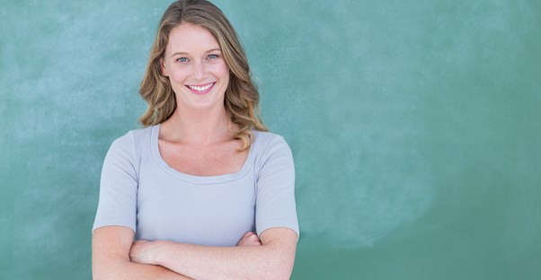 Teacher stands by a chalk board