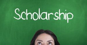 Woman looking up at a chalkboard that says scholarship