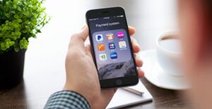 Man sitting at a table holding an iphone