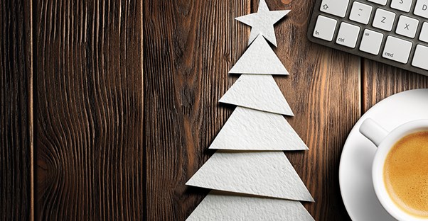 A handmade christmas tree card next to a cup of coffee and a keyboard