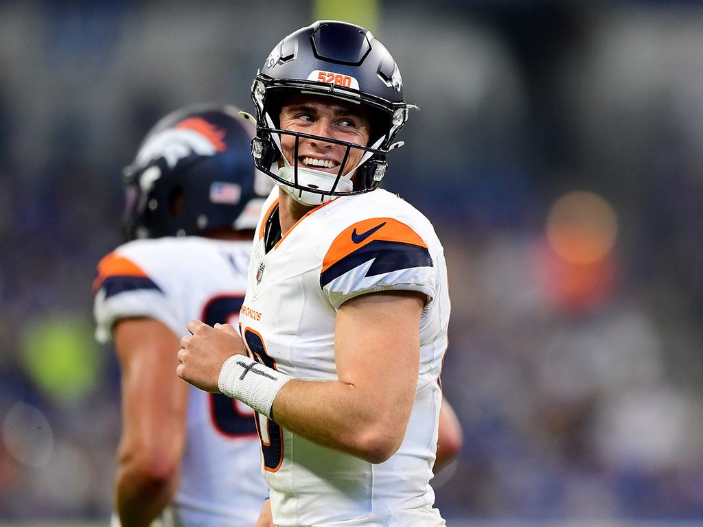 Bo Nix grins as he participates in a warm up before a game with the Denver Broncos.