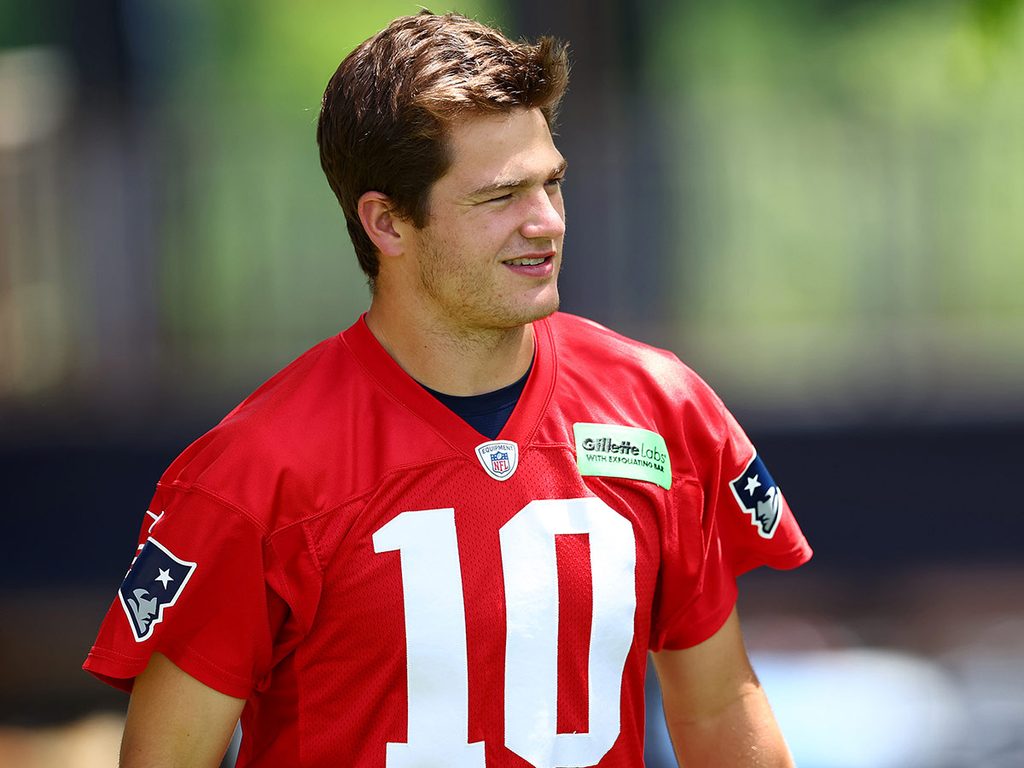 Drake Maye winks to fans after a New England Patriots practice session.