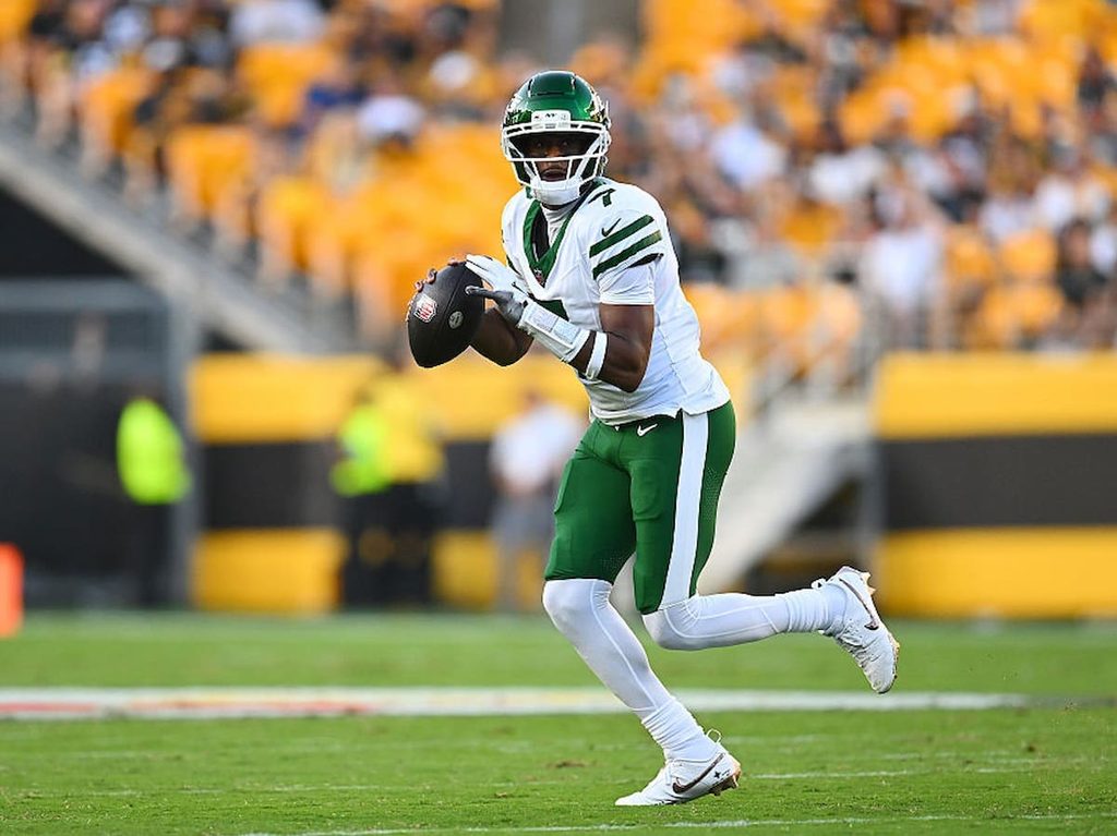 Geno Smith runs with the football during a Jets preseason game.