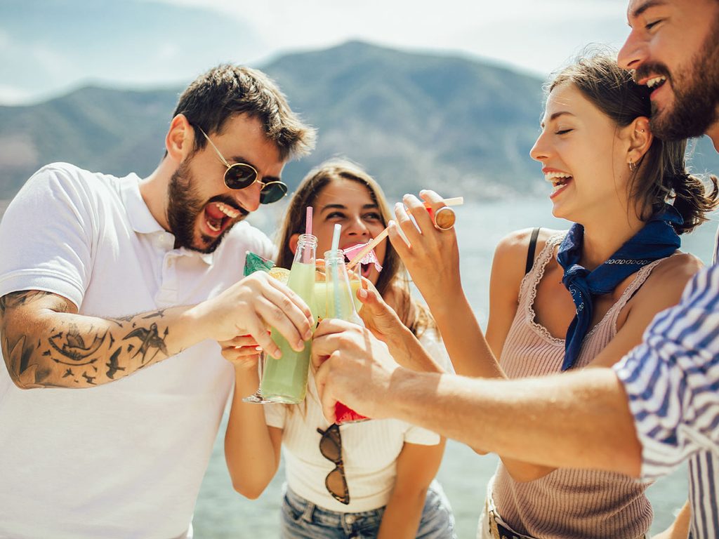 A group of millennial friends toast cocktails while on a European summer vacation.