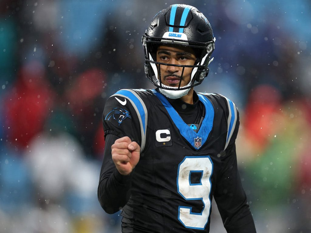 Bryce Young pumps his fist to celebrate a successful play during a game.