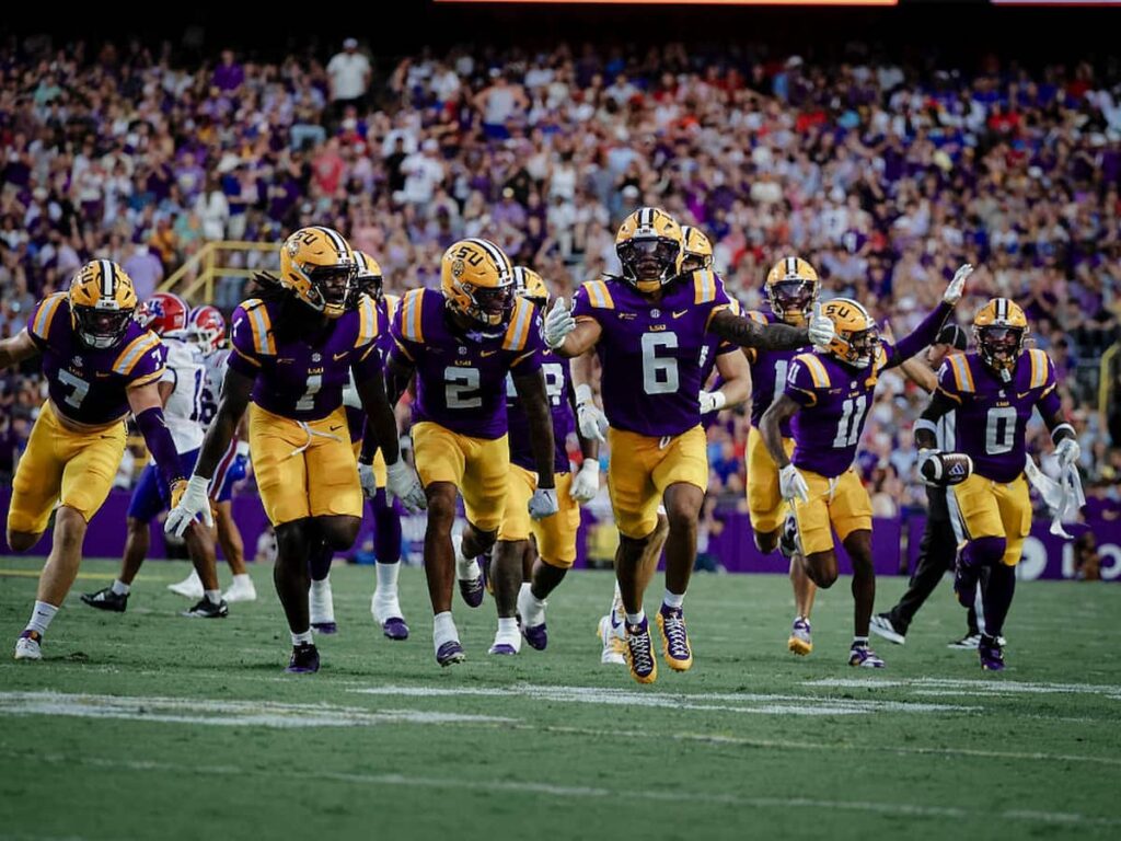 The LSU Tigers defensive line celebrates recovering a fumble during a game.