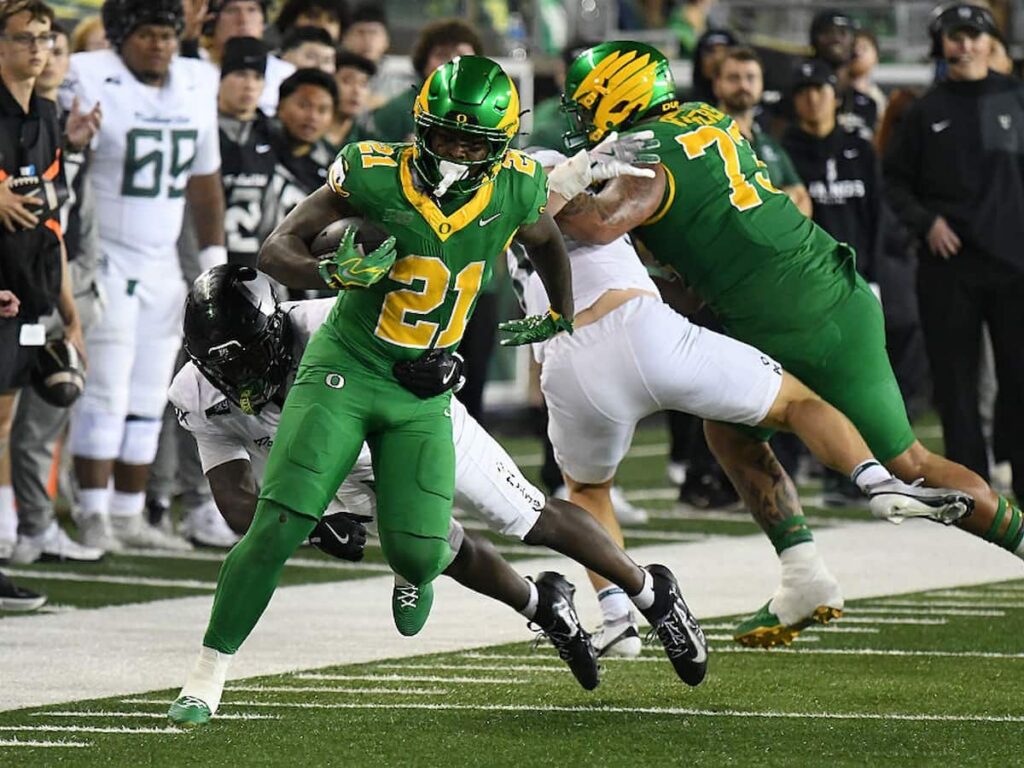 Oregon Ducks running back Dajaun Riggs escapes a tackle while running the ball.